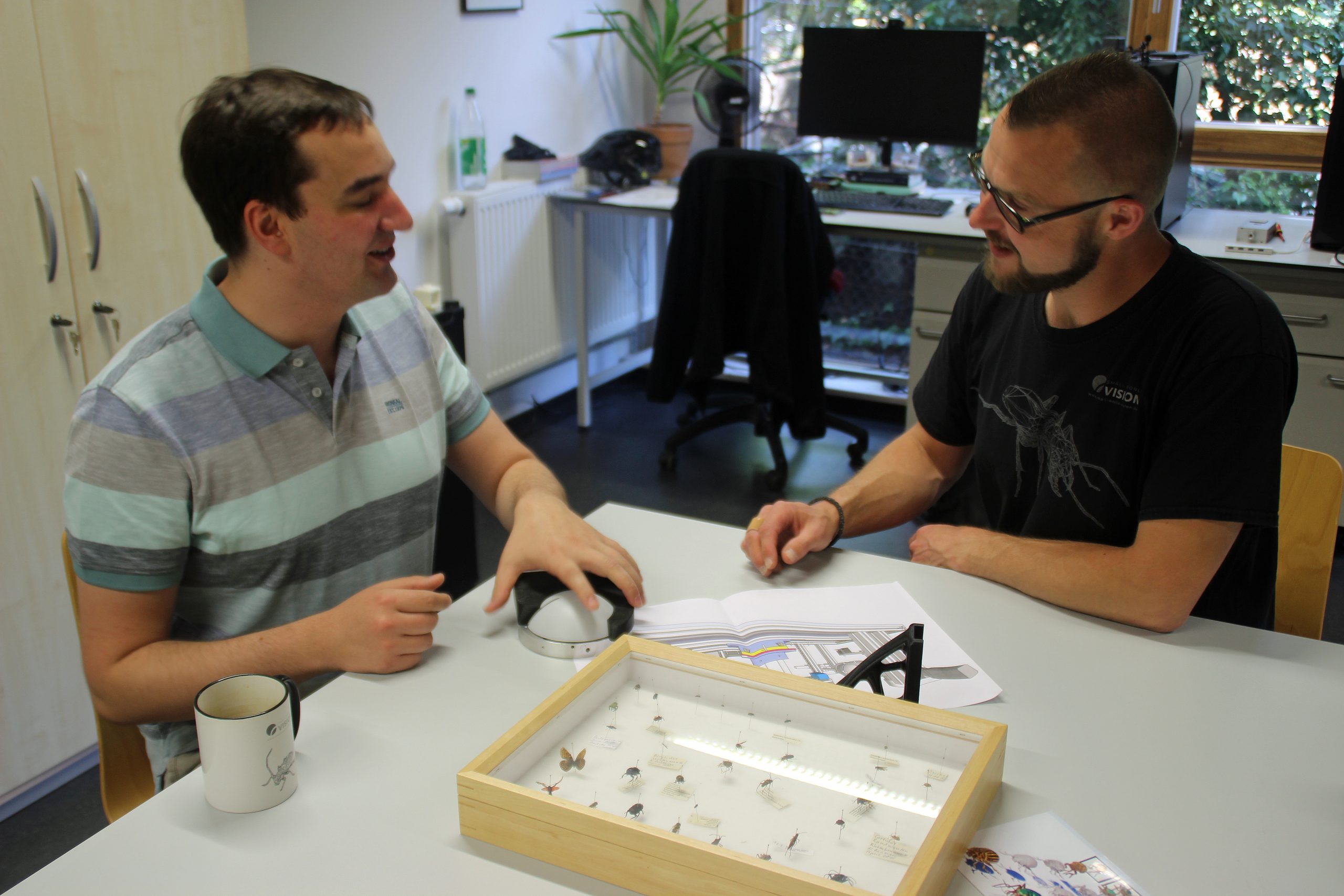Marc-Simon Stutz (li.) und Sebastian Schmelzle (re.) mit Insektensammlungskasten und Plänen zur Optimierung von DISC3Dplus. Foto: Anja Störiko.