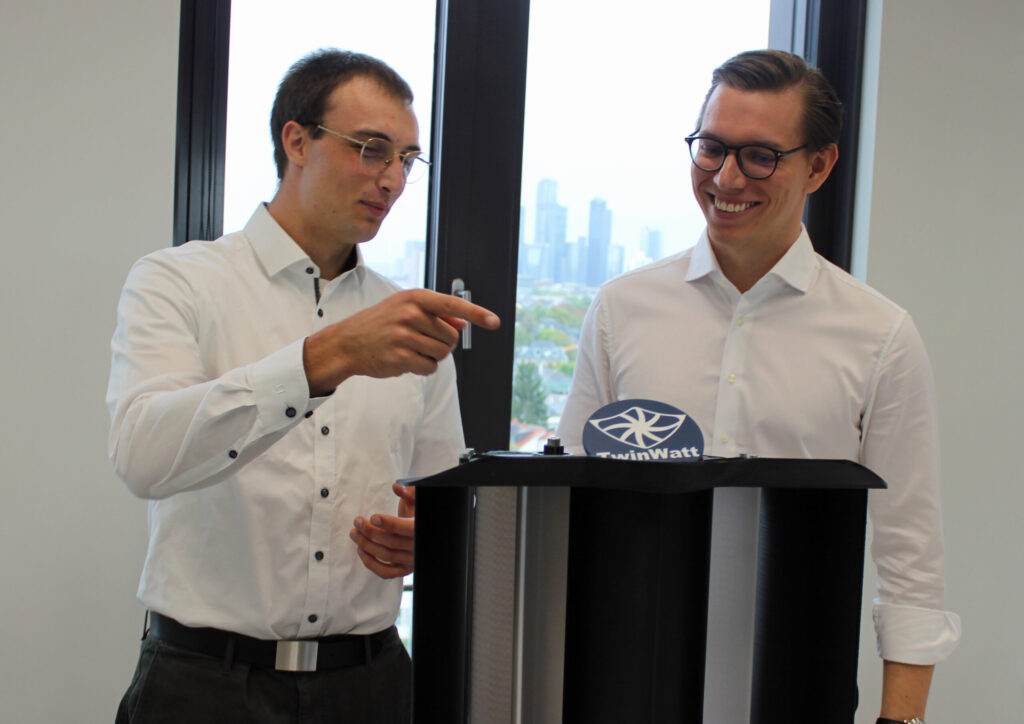 Die Gründer von TwinWatt, Erik Kohler (links) und Lorenz Tidow, zeigen ein Modell ihrer Windkraftanlage mit Doppelrotor, das in Zukunft etwa auf den Dächern der Frankfurter Skyline umweltfreundliche Energie liefern könnte. (© Anja Störiko)